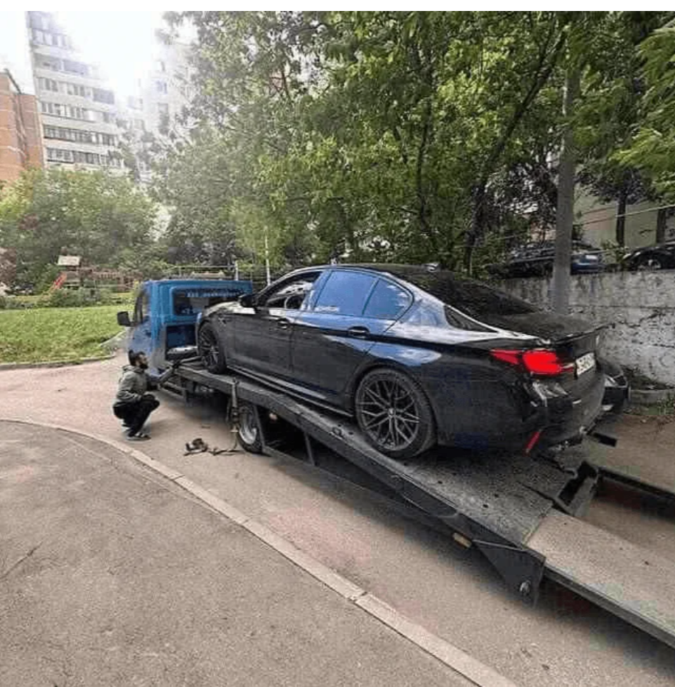 Чёрный легковой автомобиль на эвакуаторе